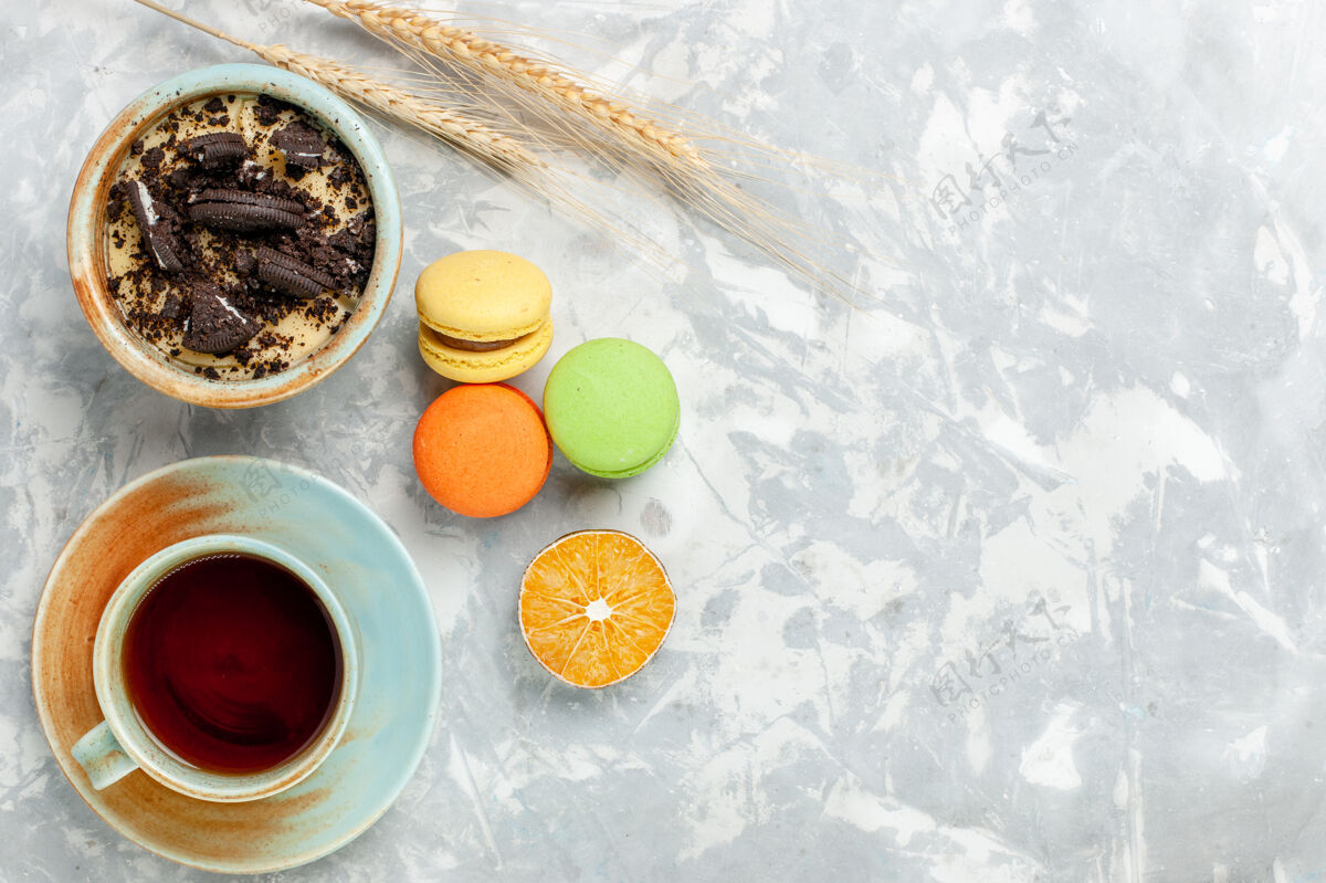 杯子顶视图一杯茶 配麦卡龙和巧克力饼干 甜点放在浅白的桌子上 甜甜的烤糖派饼干手镯麦卡龙水果