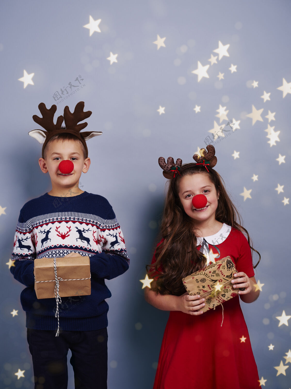 鹿角男孩和女孩与驯鹿鹿角举行礼品盒礼品盒圣诞快乐童年