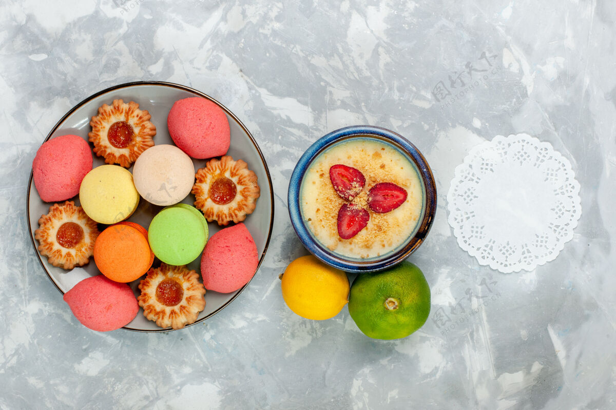 托盘俯瞰五颜六色的法国马卡龙美味蛋糕配饼干和甜点放在白色桌子上烤蛋糕甜甜甜点饼干美食风景水果