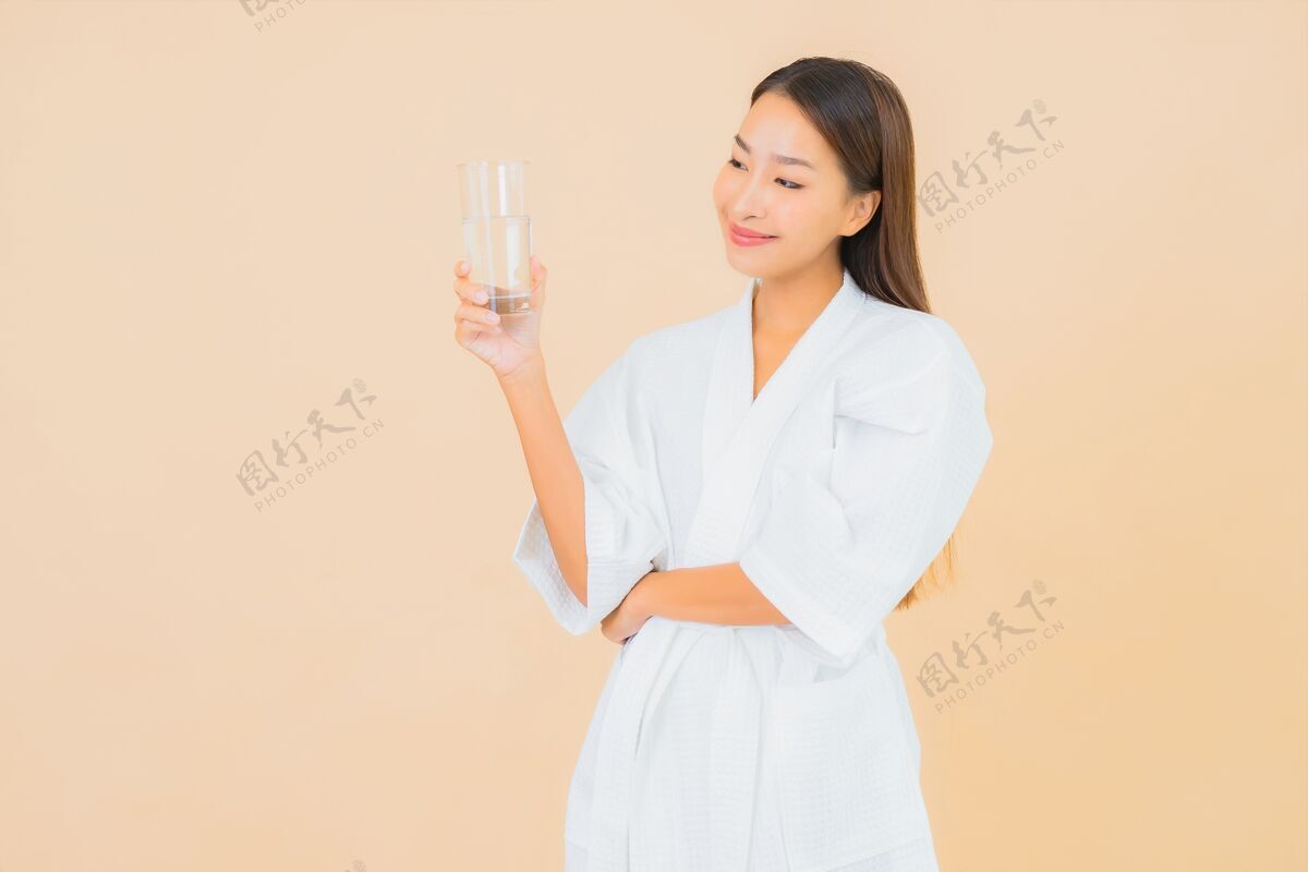 中国肖像美丽的亚洲年轻女子与瓶装水喝米色瓶子年轻人运动