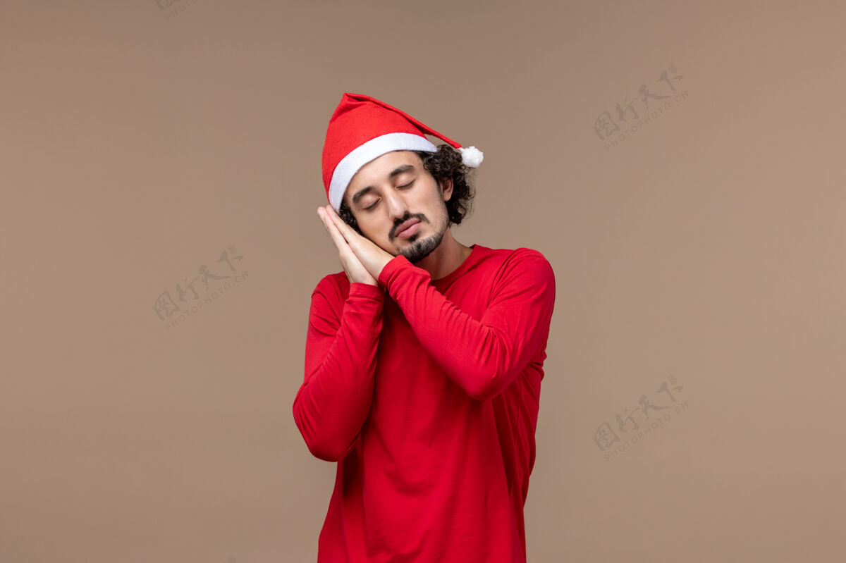 疲惫正面图年轻男性疲惫不堪 试图在棕色背景上入睡 圣诞节的情绪表情肖像艺人