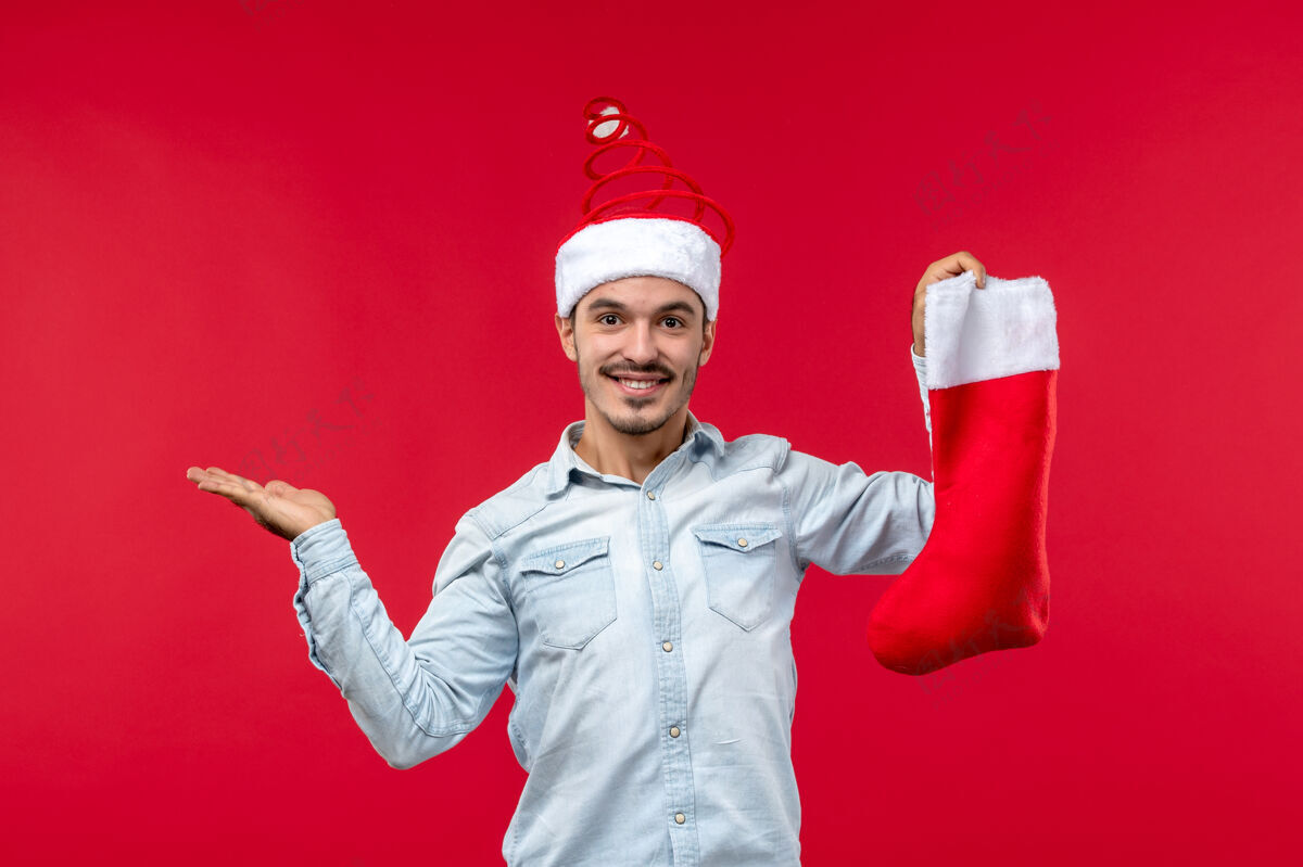 袜子前视图的年轻人与圣诞袜子摆在红墙圣诞节职业前面
