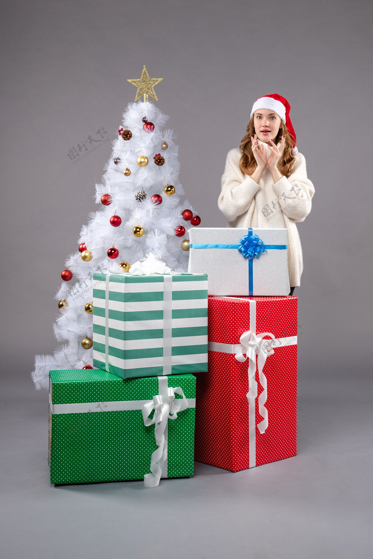 购物年轻的女性在灰色的礼物圣诞树年轻包