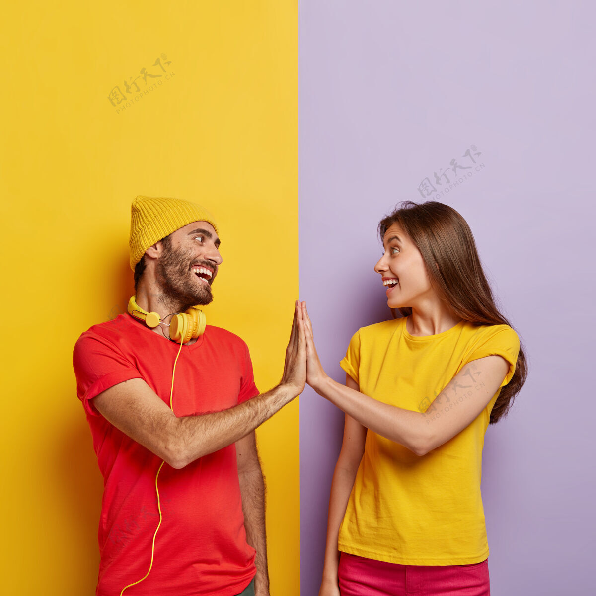 帽子高兴的男朋友和女朋友手相抚摸 积极的微笑 同意某事 穿着红黄相间的休闲t恤男性手势年轻人