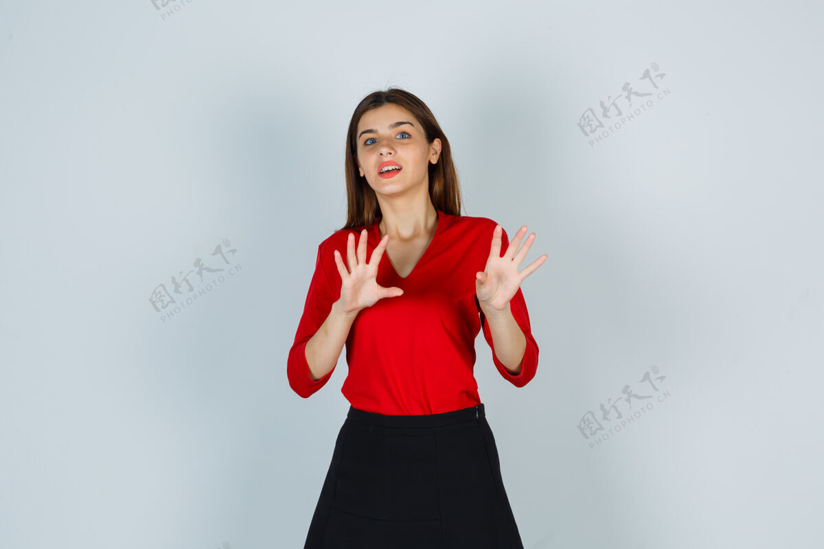 休闲一位身穿红色上衣的年轻女士 裙摆露出手掌的投降姿态 看上去很幸福手势正面肖像
