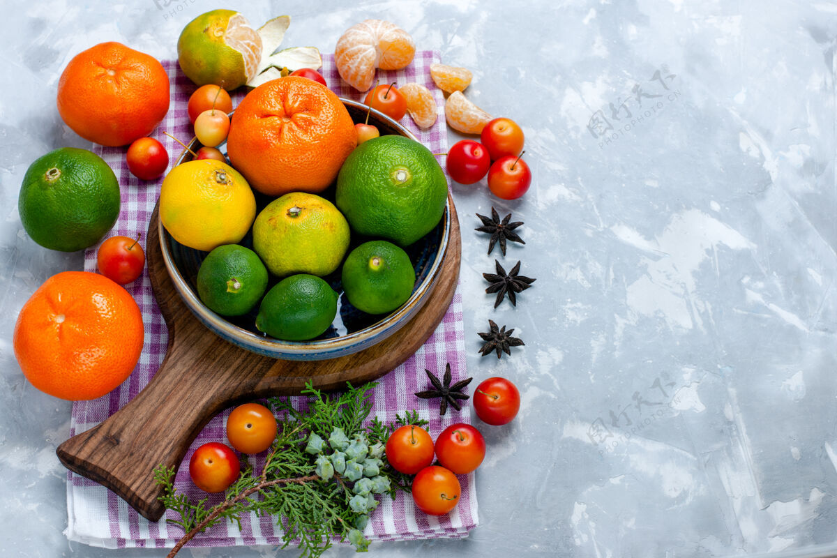水果半俯视图白色书桌上的酸味鲜橘配柠檬和李子柑橘异国情调的热带水果维生素酸味酸的柑橘办公桌