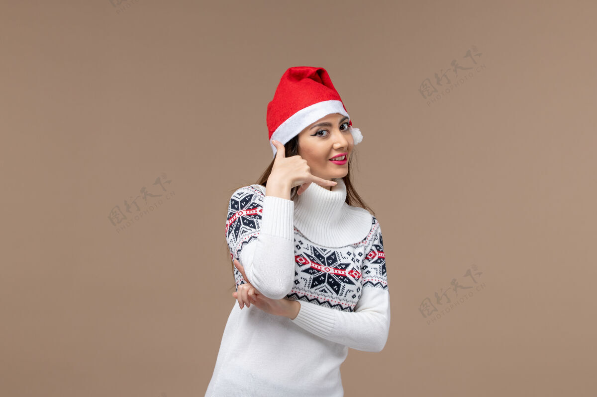 帽子正面图棕色背景上微笑的年轻女性圣诞假期感慨孩子肖像女性