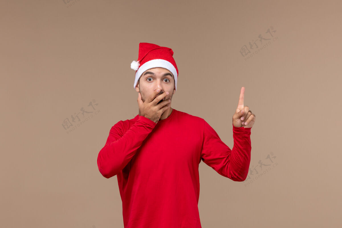 年轻男性正面图棕色背景上一脸惊讶的年轻男性圣诞情感节日男性人服装成人