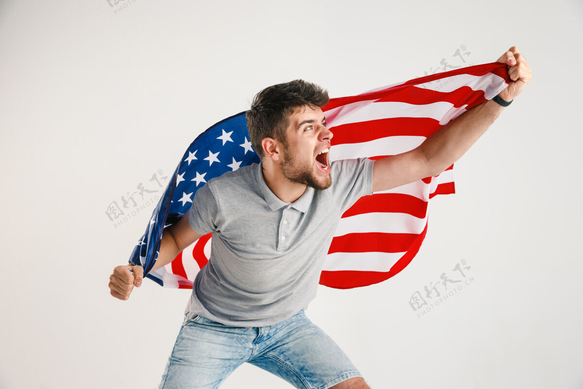 明亮拿着美国国旗的年轻人庆祝美国七月