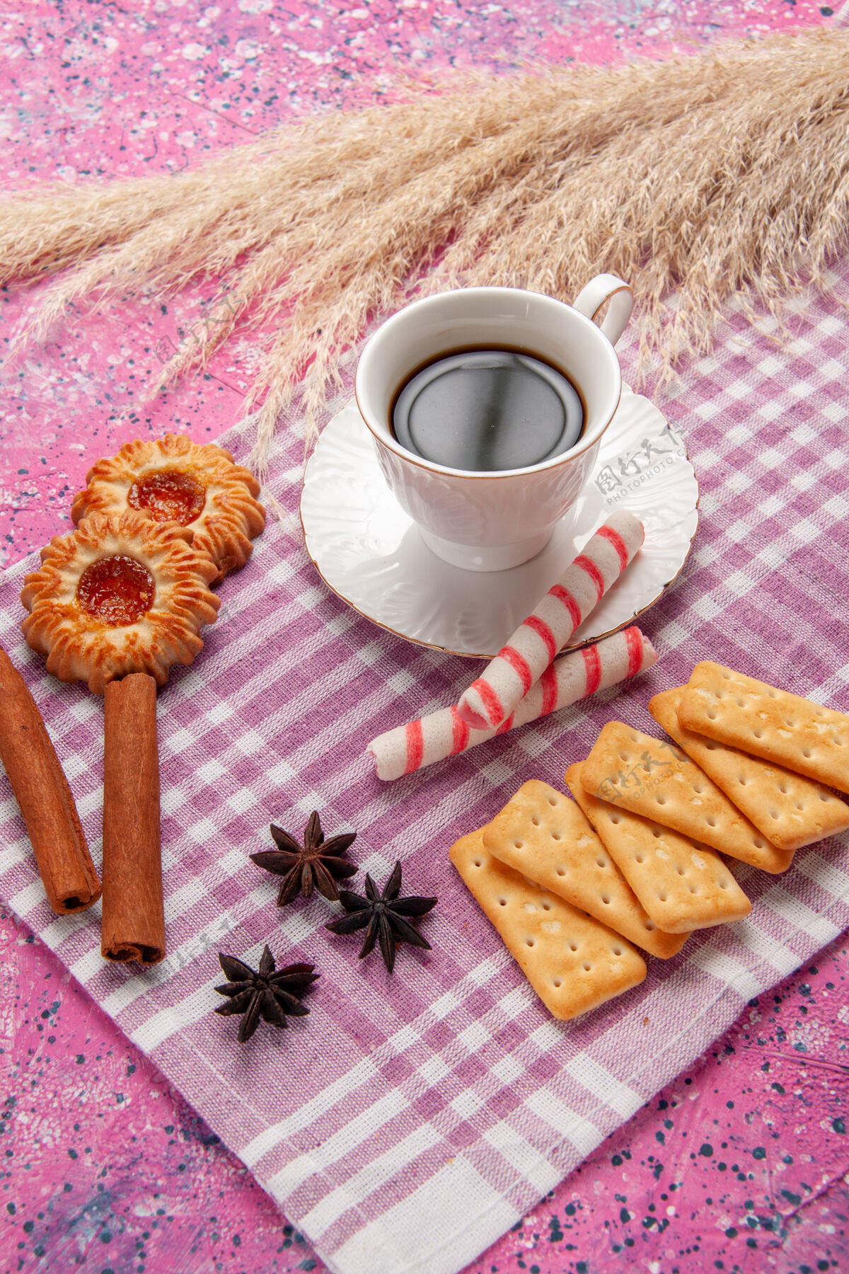 桌子前视一杯茶加肉桂饼干和饼干放在粉色桌上饼干糖甜烤营养品曲奇饼咖啡