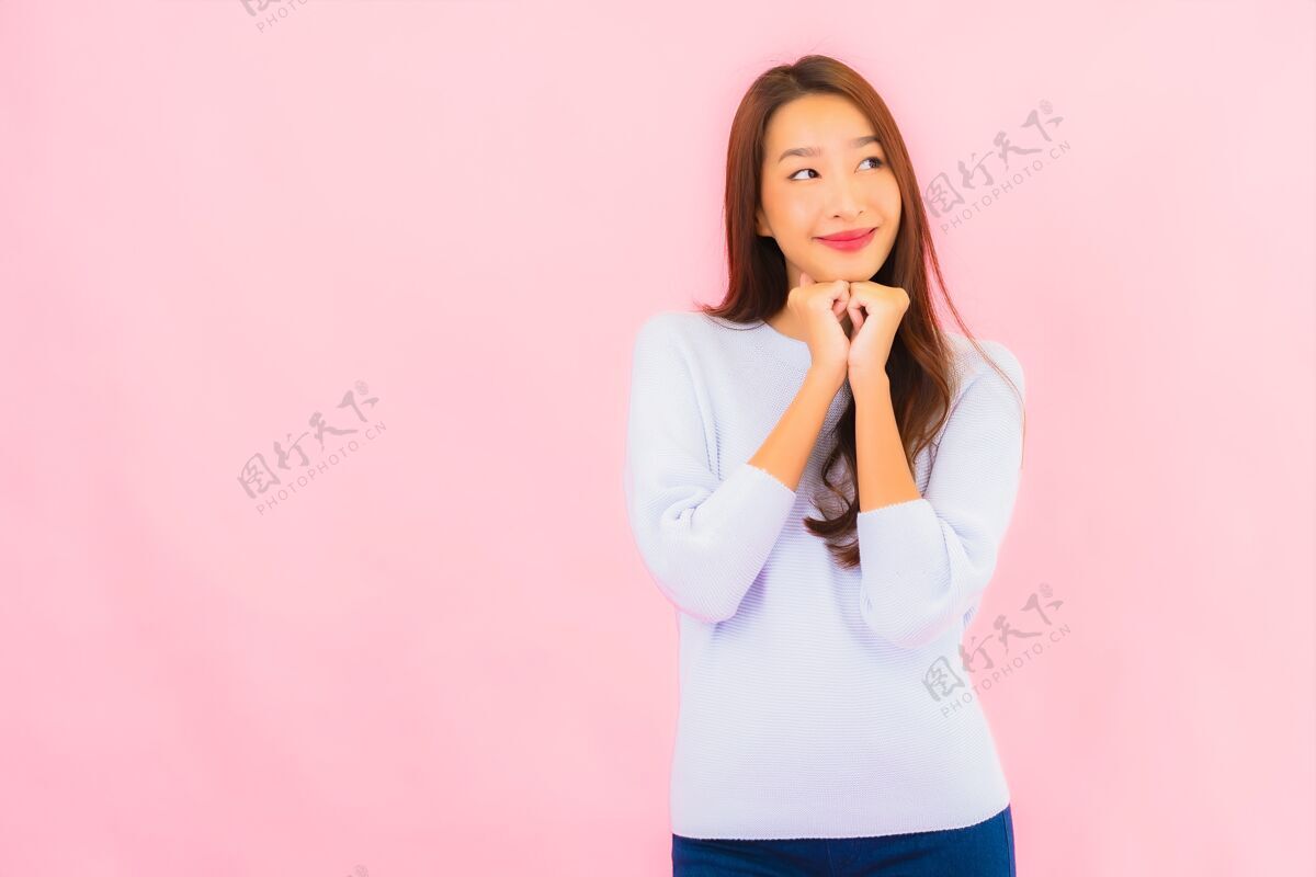 化妆美丽的亚洲年轻女子在粉红色的隔离墙上微笑韩语漂亮女人