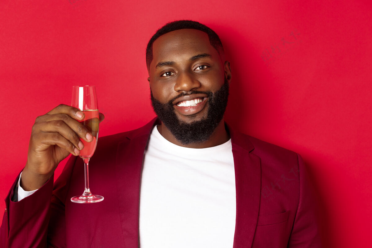 年轻特写镜头：英俊微笑的黑人男子举杯祝酒 香槟快乐酒杯男士