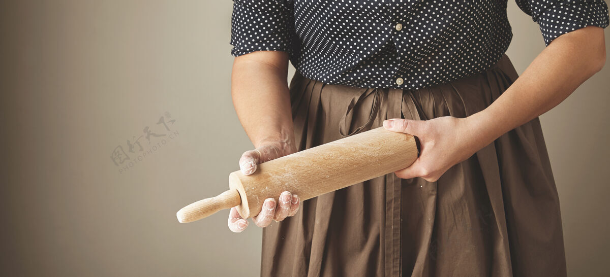 自制女人手里拿着木擀面杖 用面粉搓着擀面杖模具厨师配料