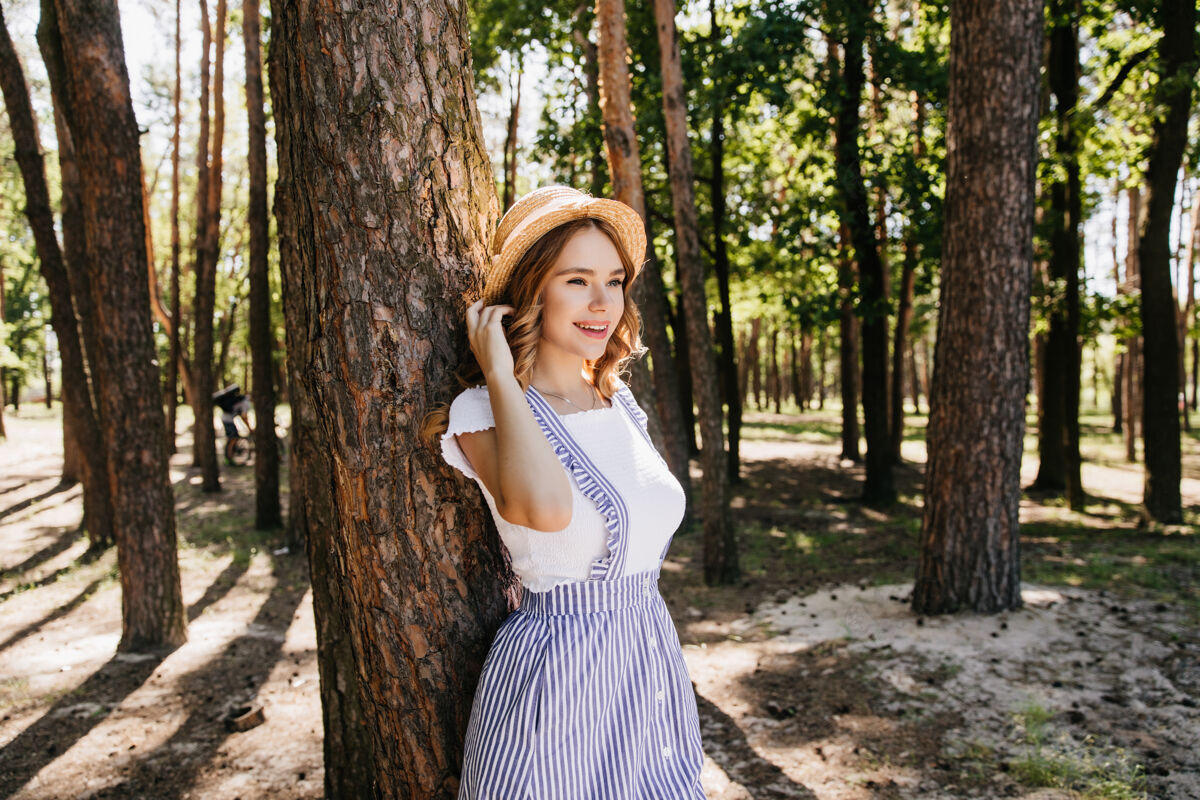 草戴草帽的优雅女孩在享受夏日的美好时光优雅的女模特在森林中微笑着摆姿势的户外照片无忧无虑绿色户外