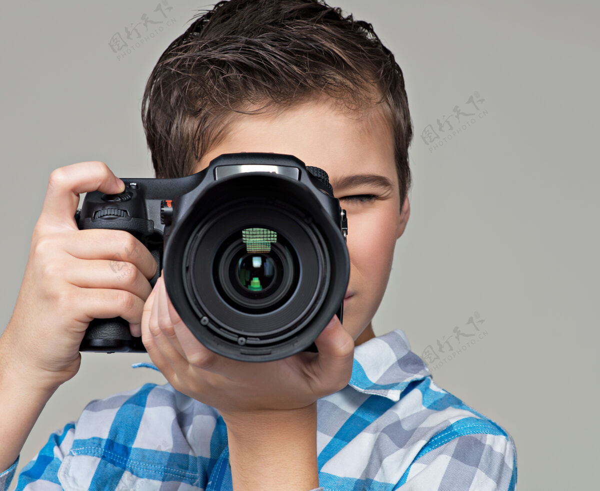 孩子男孩用单反相机拍照十几岁的男孩拿着相机拍照拍摄爱好镜头
