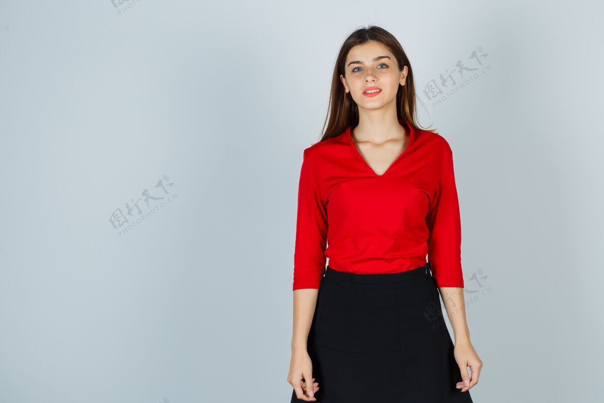 年轻年轻的女士站在那里摆姿势 穿着红色的衬衫 裙子 看起来很精致肖像花健康