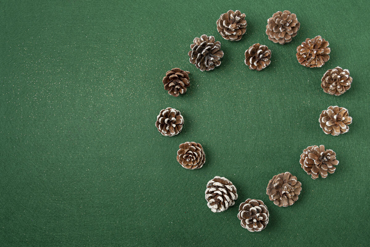 明亮松果圣诞装饰品平放在绿色的表面上圆锥体装饰装饰