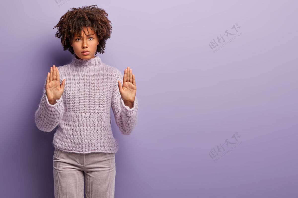 否认不 我拒绝美丽愤怒的黑皮肤女人伸出手掌 用双手做停止的手势 表示不同意 穿着休闲套头衫 站在紫色的墙上 复制空间的权利脆非洲禁止