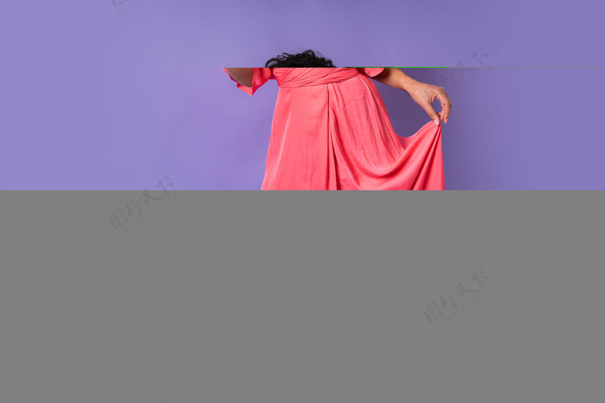 蓝色一位年轻快乐的巴西女性 卷发 穿着粉色时髦的裙子 拿着一杯咖啡摆姿势紫色墙壁上的香槟派对气氛非洲优雅头发