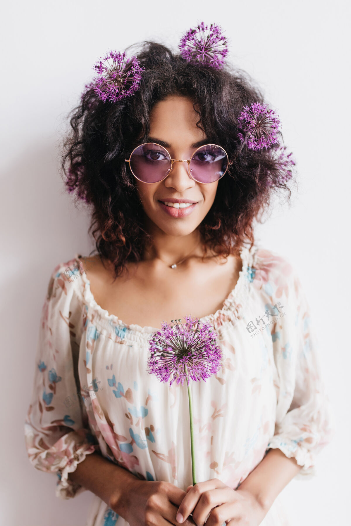 成人戴着太阳镜的迷人非洲女孩与葱合影室内拍摄可爱卷曲的紫花女模特乐趣美丽正面