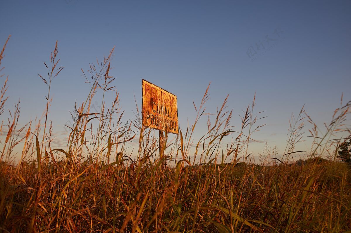 空气低角度拍摄的标志在一个农业领域与一个明确的蓝天日落蓝色下午