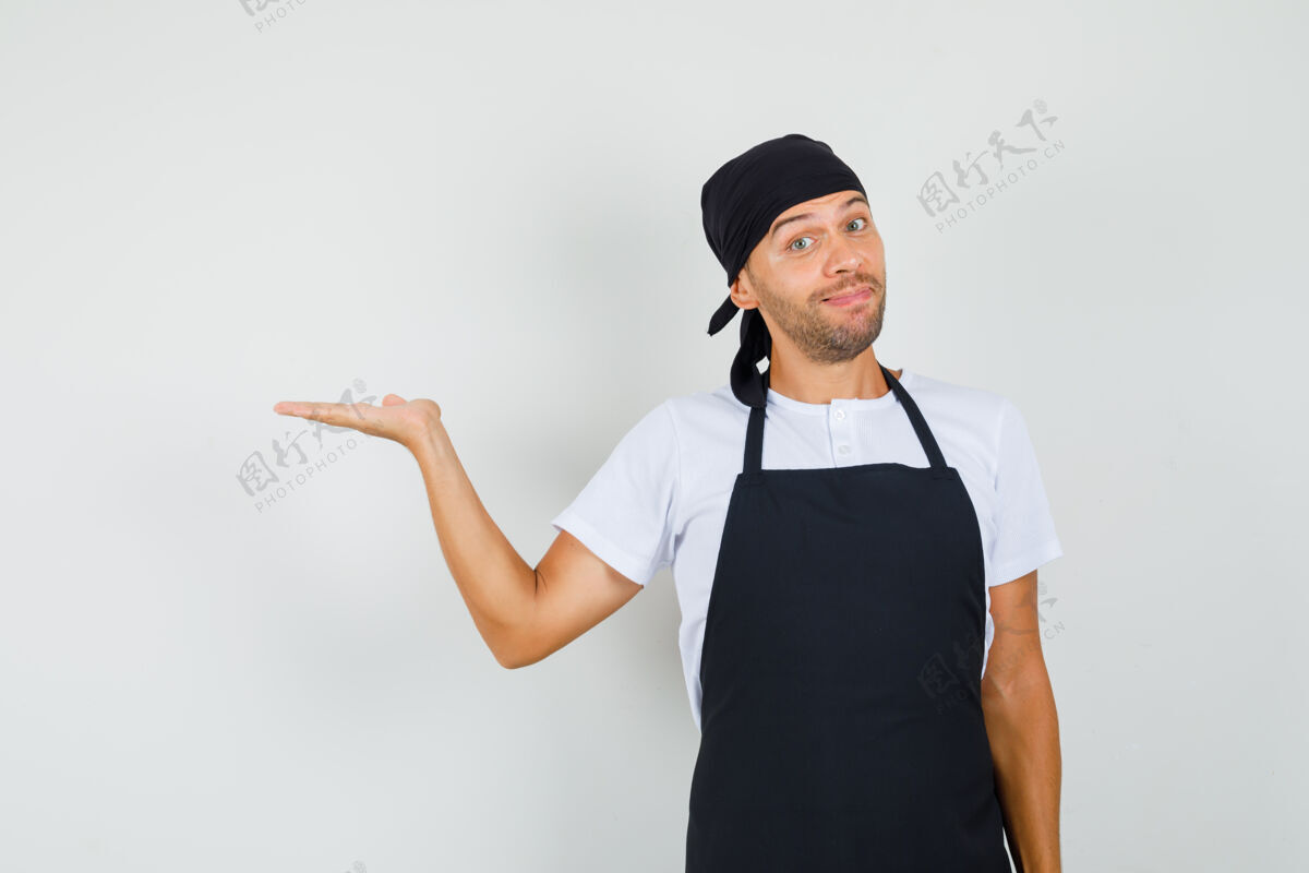 职业面包师举起手掌 拿着或展示t恤衫上的东西男人美味美食家