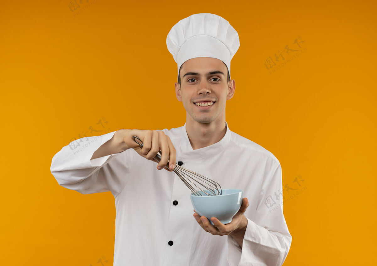 持有笑容可掬的男青年 穿着厨师制服 手里拿着威士忌和碗碗穿着厨师