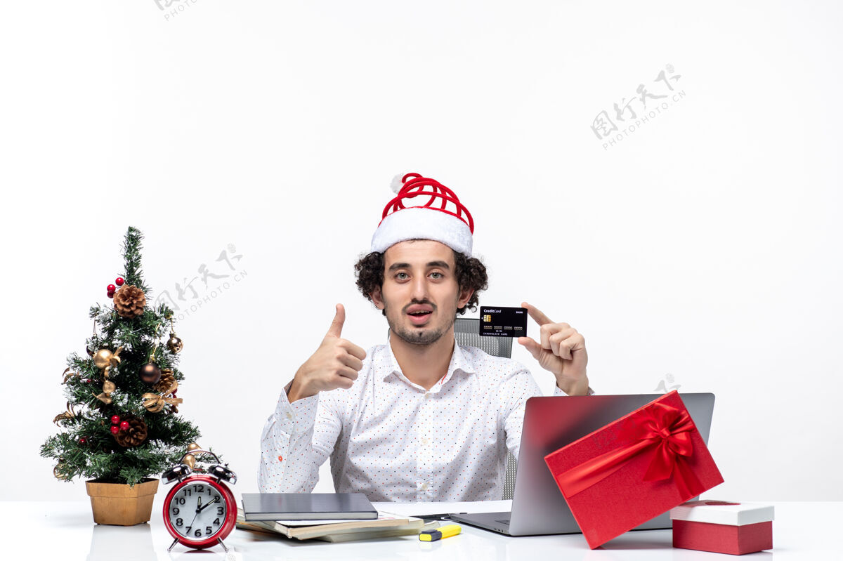 银行圣诞节心情与年轻的胡须震惊骄傲的商人与圣诞老人帽子举行银行卡白色背景胡须微笑成人