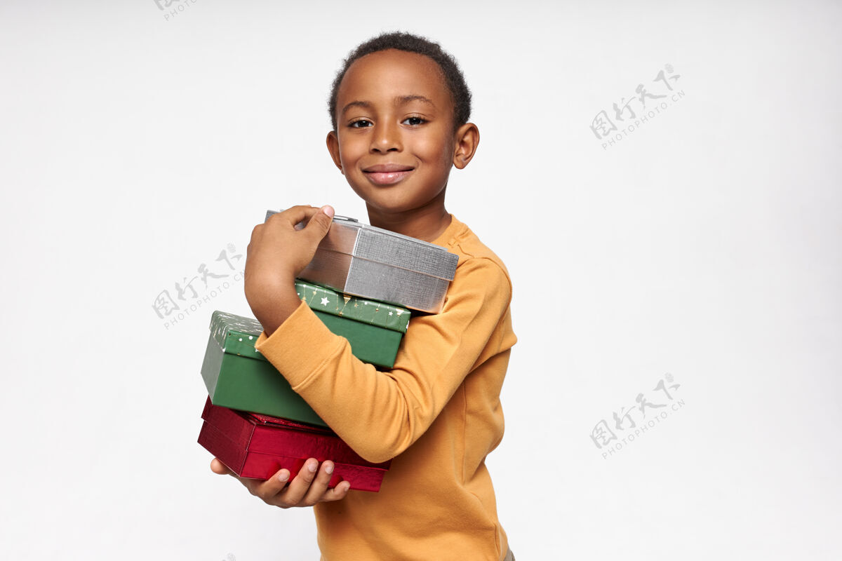 黑色一幅欢快的非洲男孩背着盒子 接受礼物 面带喜悦的微笑看着前方的画像生日庆祝小