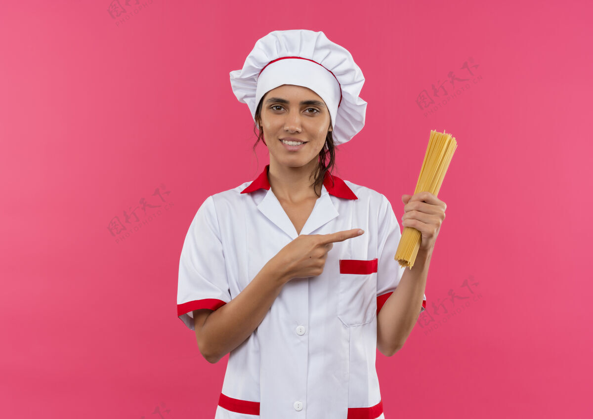 意大利面面带微笑的年轻女厨师穿着厨师制服拿着点意大利面和复印空间厨师制服女
