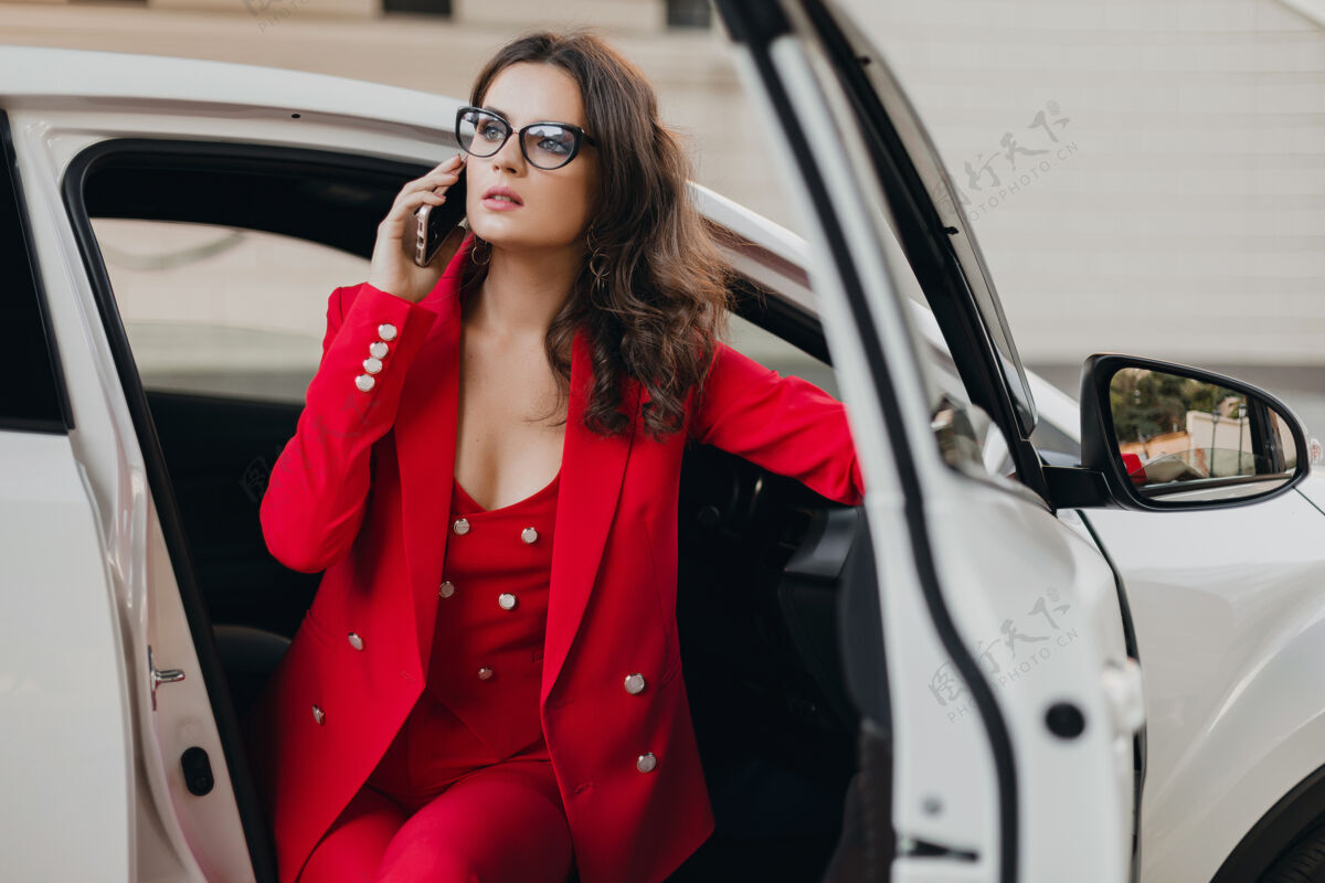 女人穿着红西装的美女性感富婆坐在白车里 戴着眼镜讲电话 商务小姐风范智能手机女士女孩