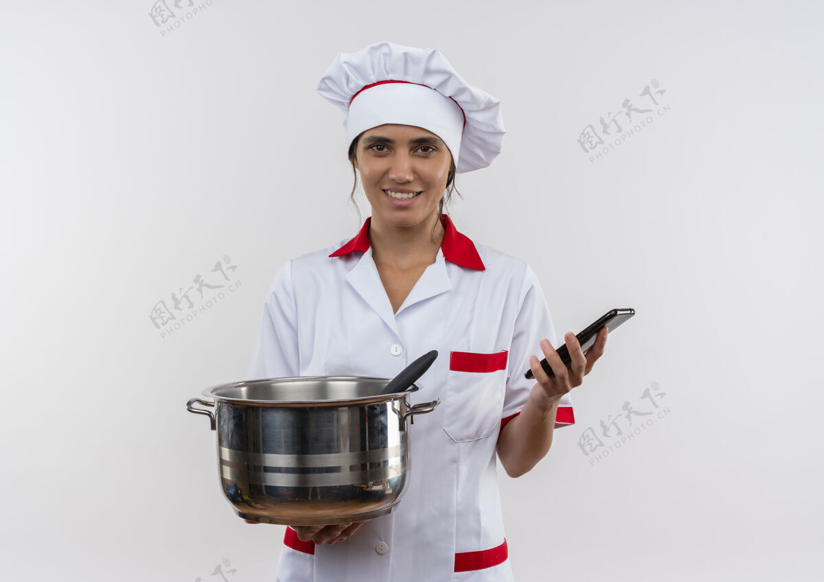 拿着面带微笑的年轻女厨师穿着厨师制服拿着平底锅和带复印空间的电话厨师女平底锅