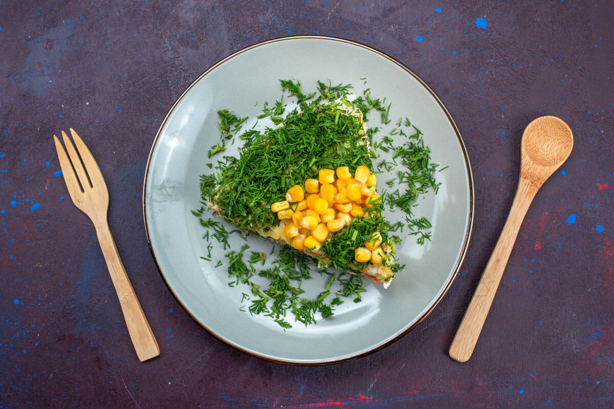 食物在黑暗的桌子上 盘子里放着美味的沙拉 蛋黄酱 蔬菜 玉米和鸡肉蛋黄酱绿色玉米