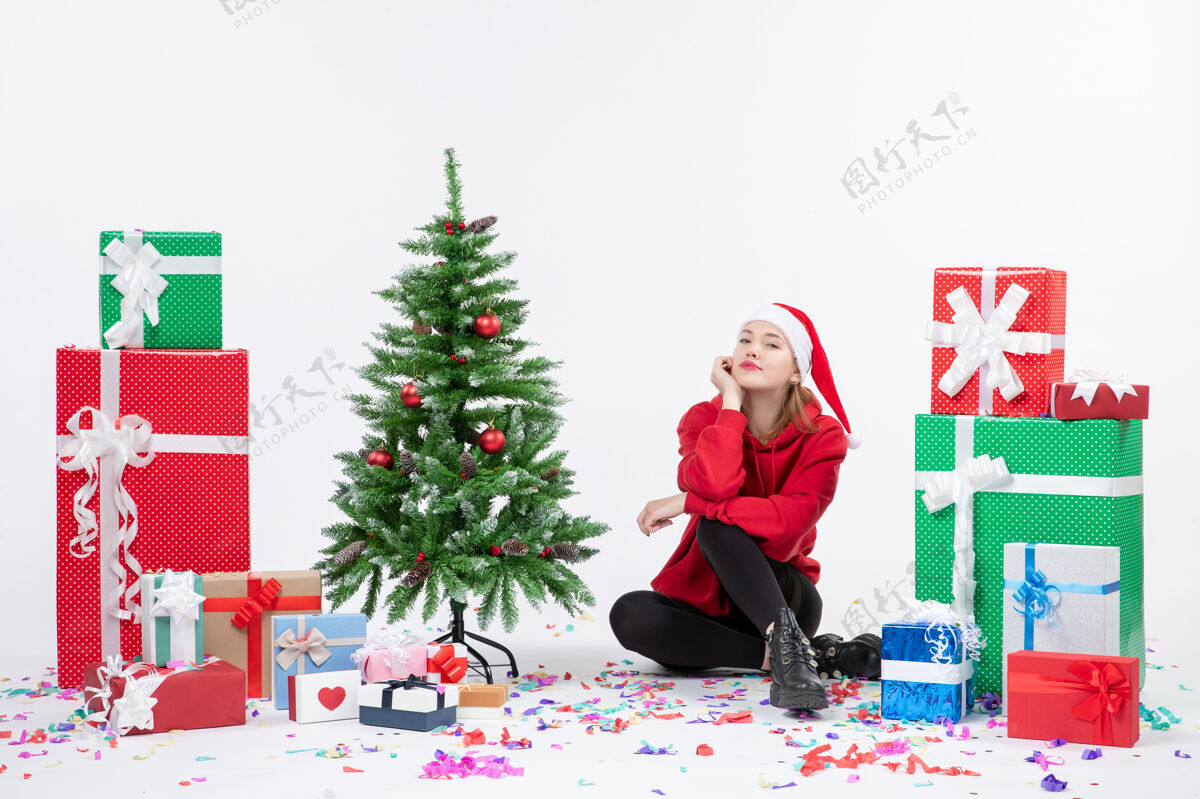 圣诞年轻女子围坐在白色墙壁上的不同节日礼物的前视图礼物人装饰