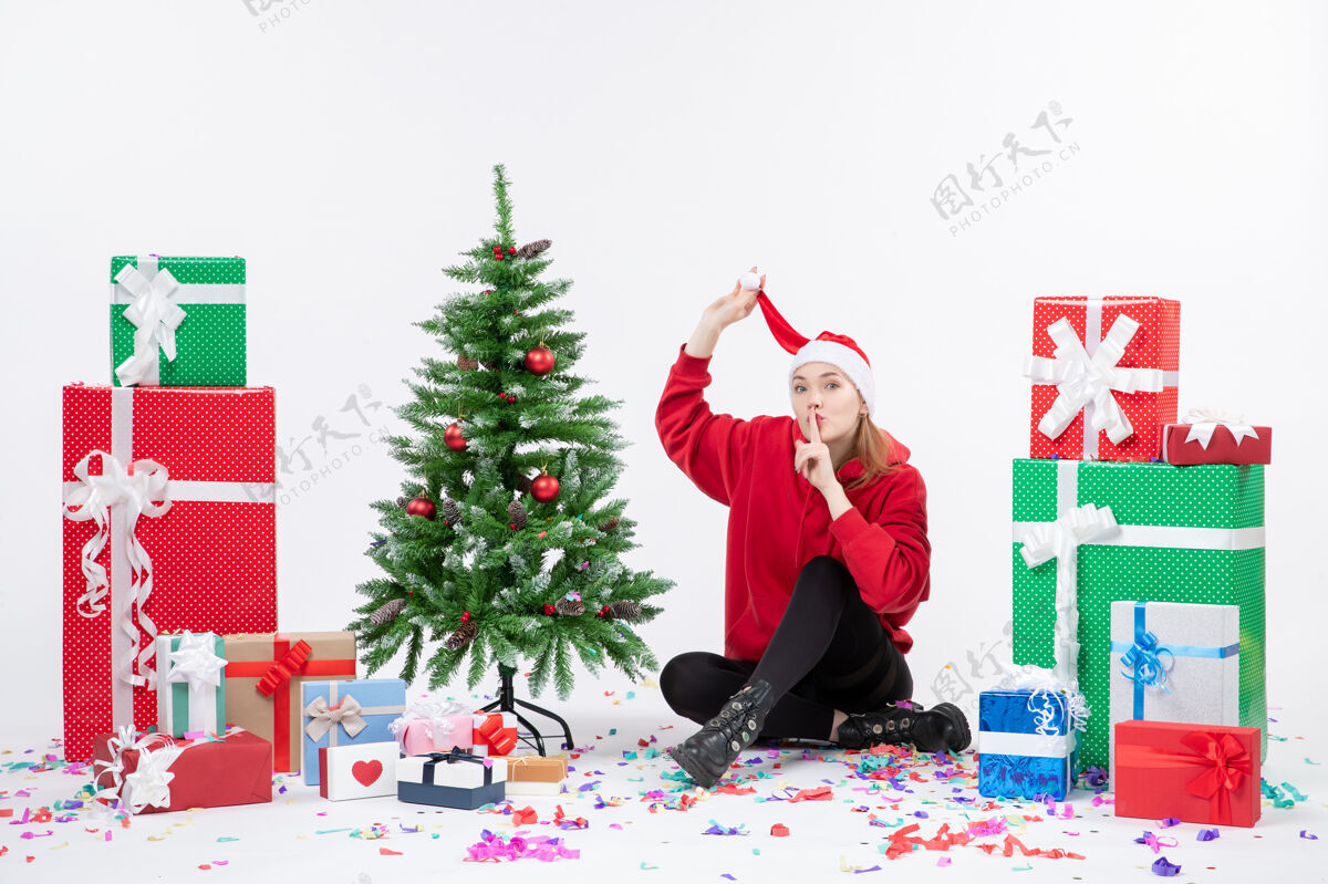 人年轻女子围坐在白墙上的礼物面前圣诞节日前面