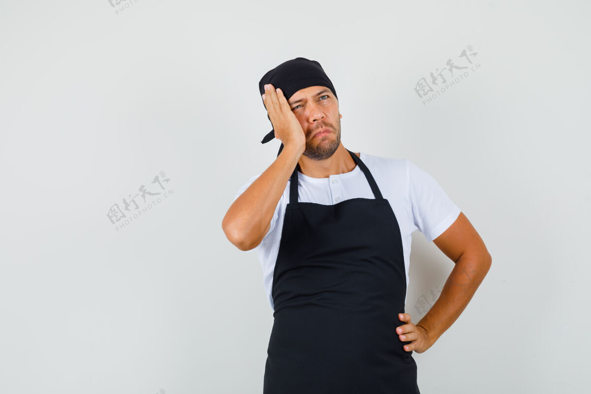 制服面包师穿着t恤 围裙抬头看着 神情沉思生意人食物