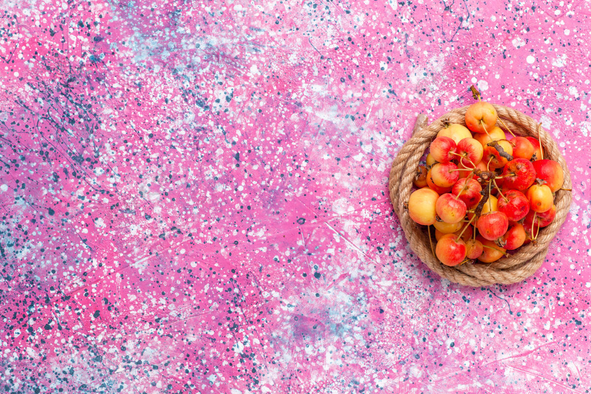 水果在粉色背景上用绳子顶着新鲜的甜樱桃樱桃石榴腰子