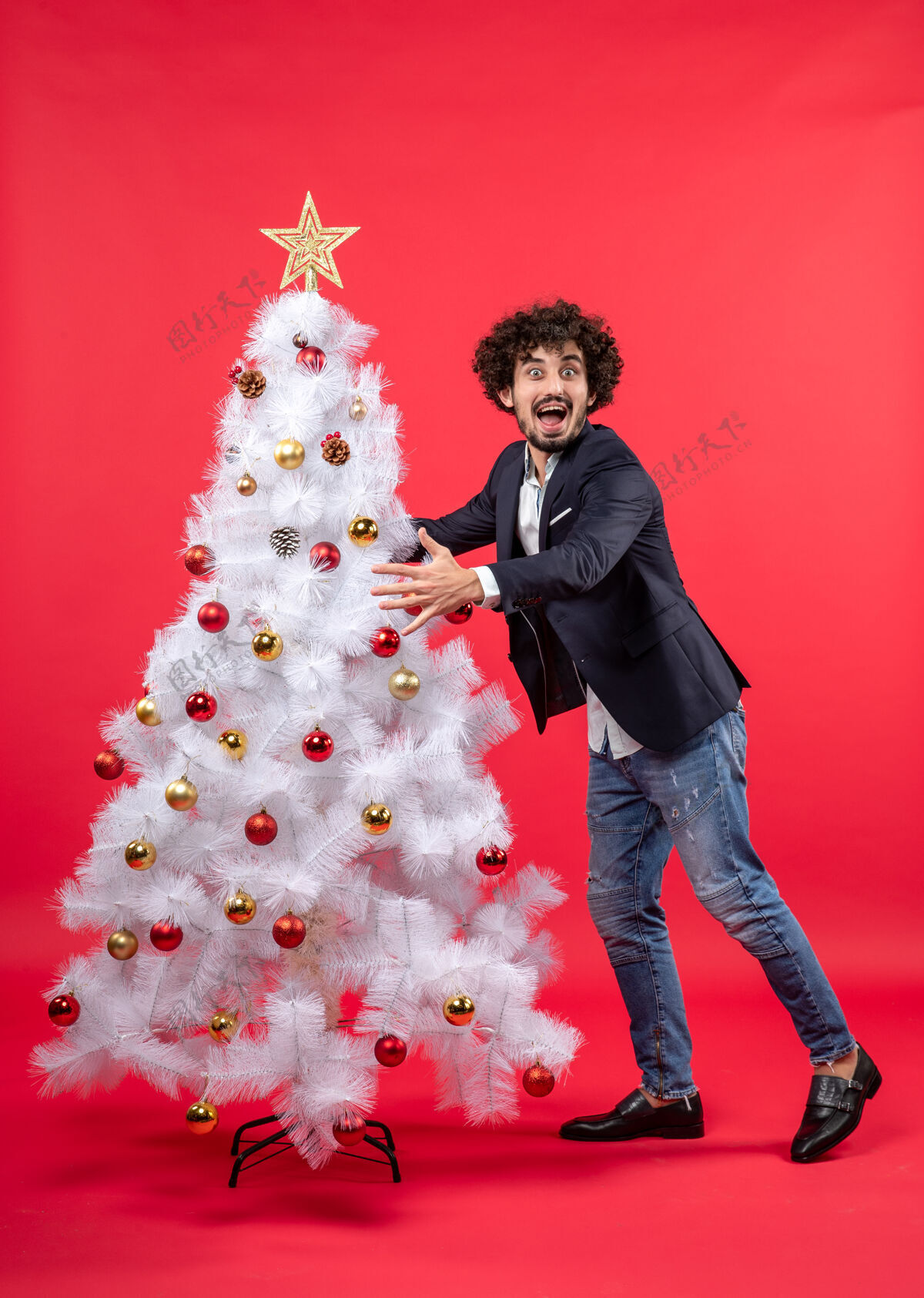 庆祝圣诞庆祝与年轻快乐兴奋有趣的男子拥抱圣诞树微笑装饰快乐