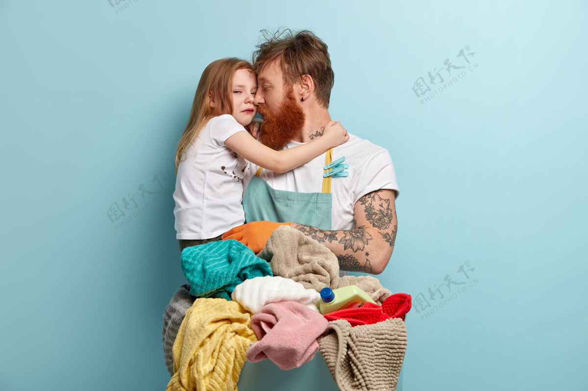 女的单身父亲抱着哭泣的小女儿的形象洗衣家脏的