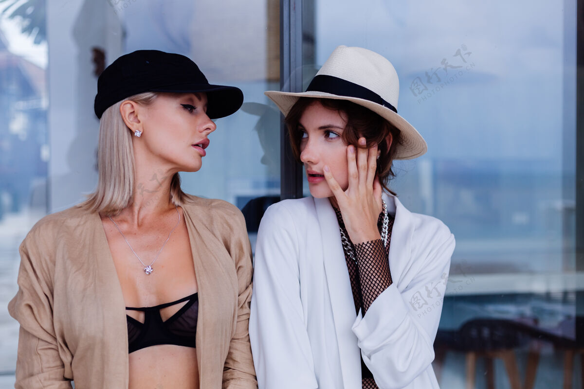 生活方式时尚肖像两个时尚的白人妇女在西装法国帽和经典的白色帽子站自信配饰皮肤