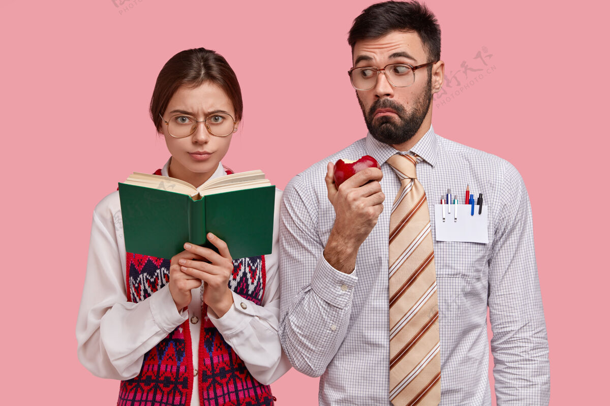 眼镜严肃聪明的女学生戴着厚镜片眼镜拿着手册 在室内学习 惊讶的大胡子男人穿着正式的衬衫个性青少年文学