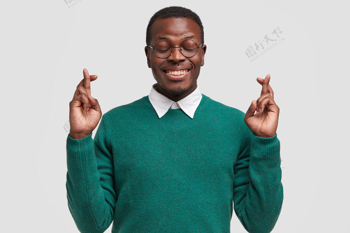 眼镜微笑的美国黑人男子祈祷他的愿望得到实现 交叉手指 祝好运考试眼镜大学