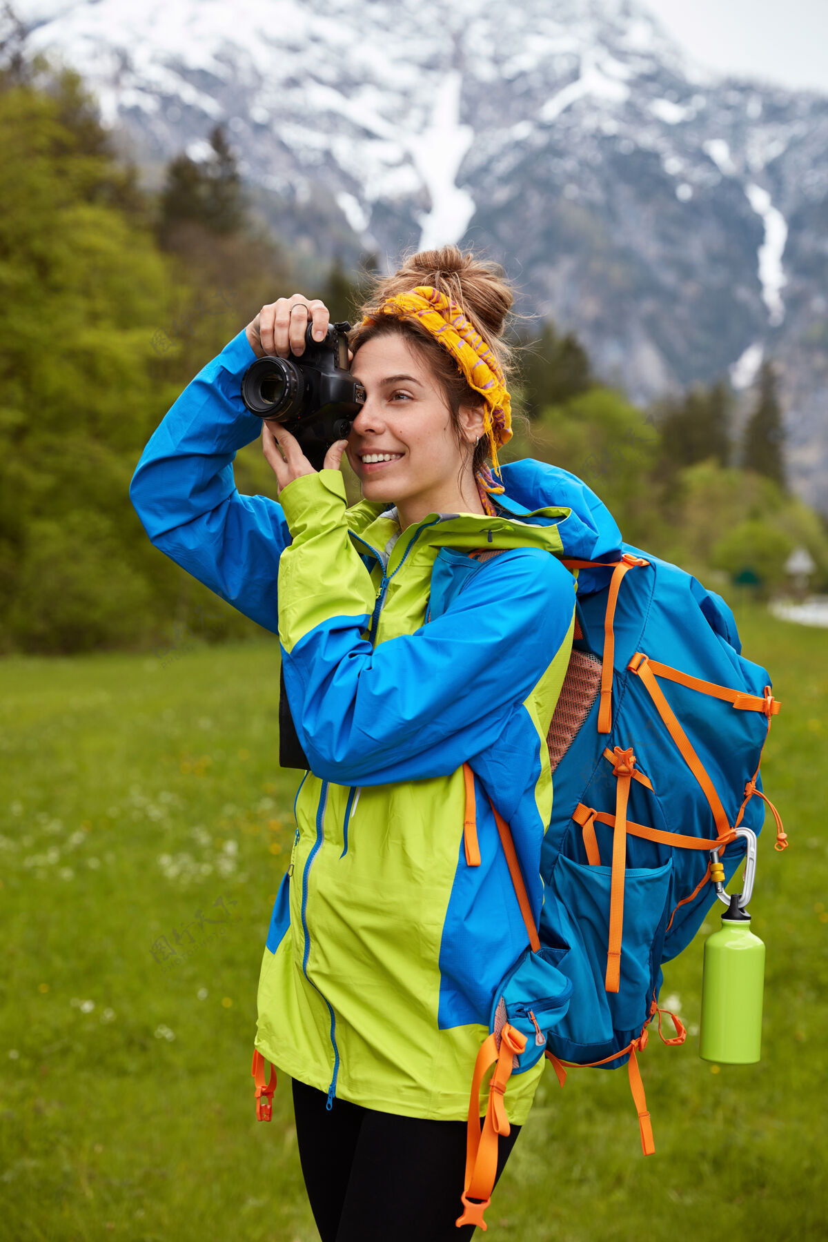 积极欢快的女旅行者的垂直镜头聚焦于风景优美的自然景观背包高兴高兴