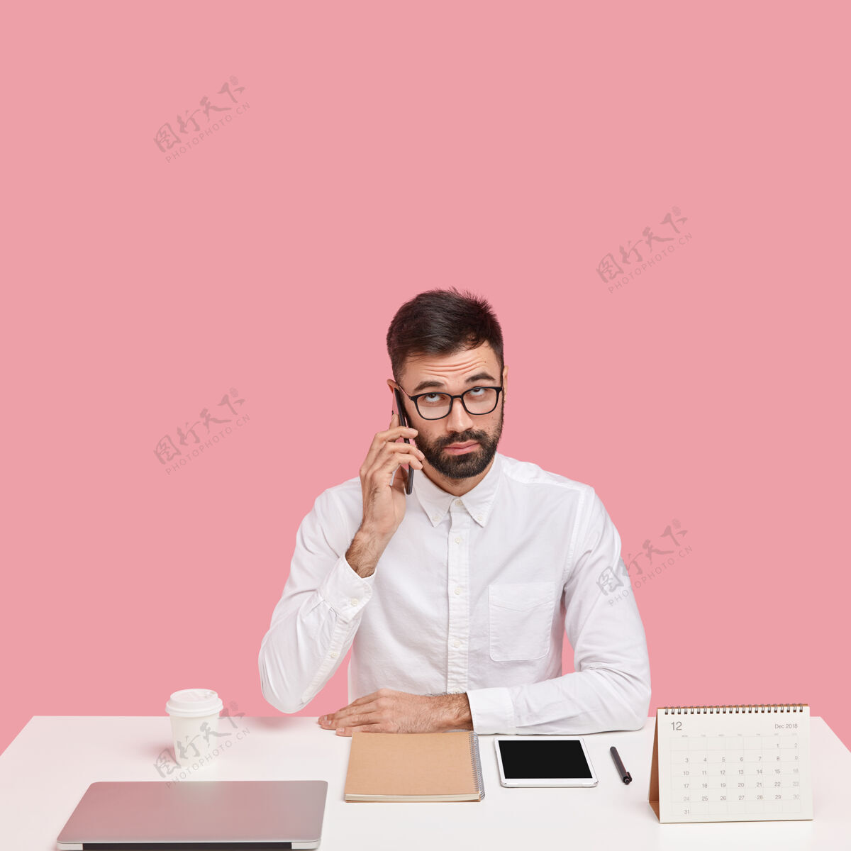 企业家严肃不刮胡子的聪明男人打电话给客户服务 在工作间隙打电话 穿着白衬衫 专注向上休息的人现代人衬衫