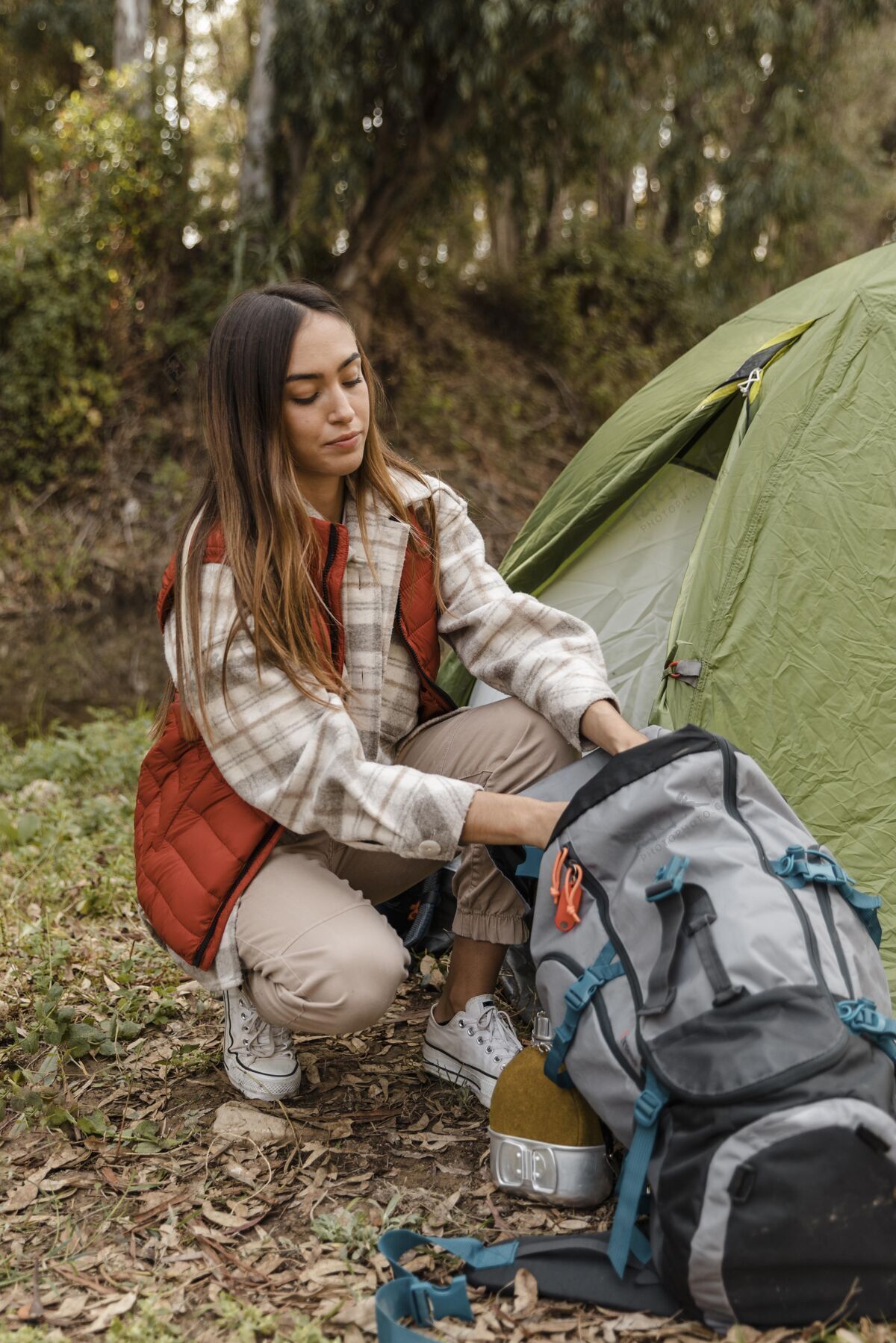 自然快乐的野营女孩在森林里打包户外旅行露营