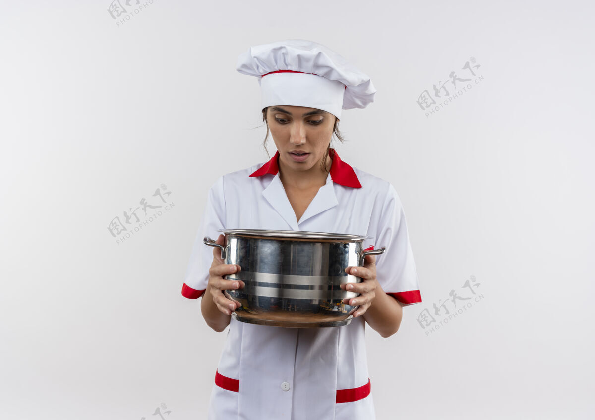 厨师惊讶的年轻女厨师穿着厨师制服拿着一个看起来有复制空间的平底锅惊讶平底锅女