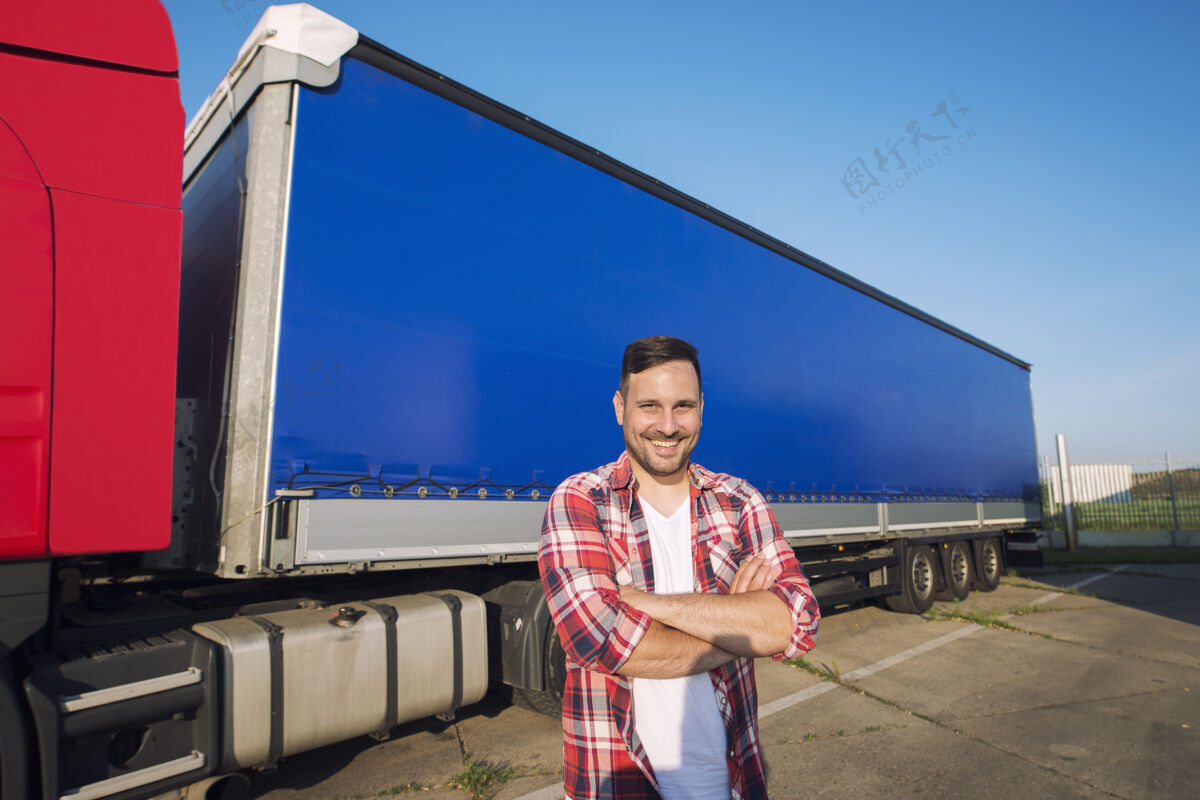 工业中年卡车司机的画像 双臂交叉 站在卡车拖车旁准备驾驶国家人工作