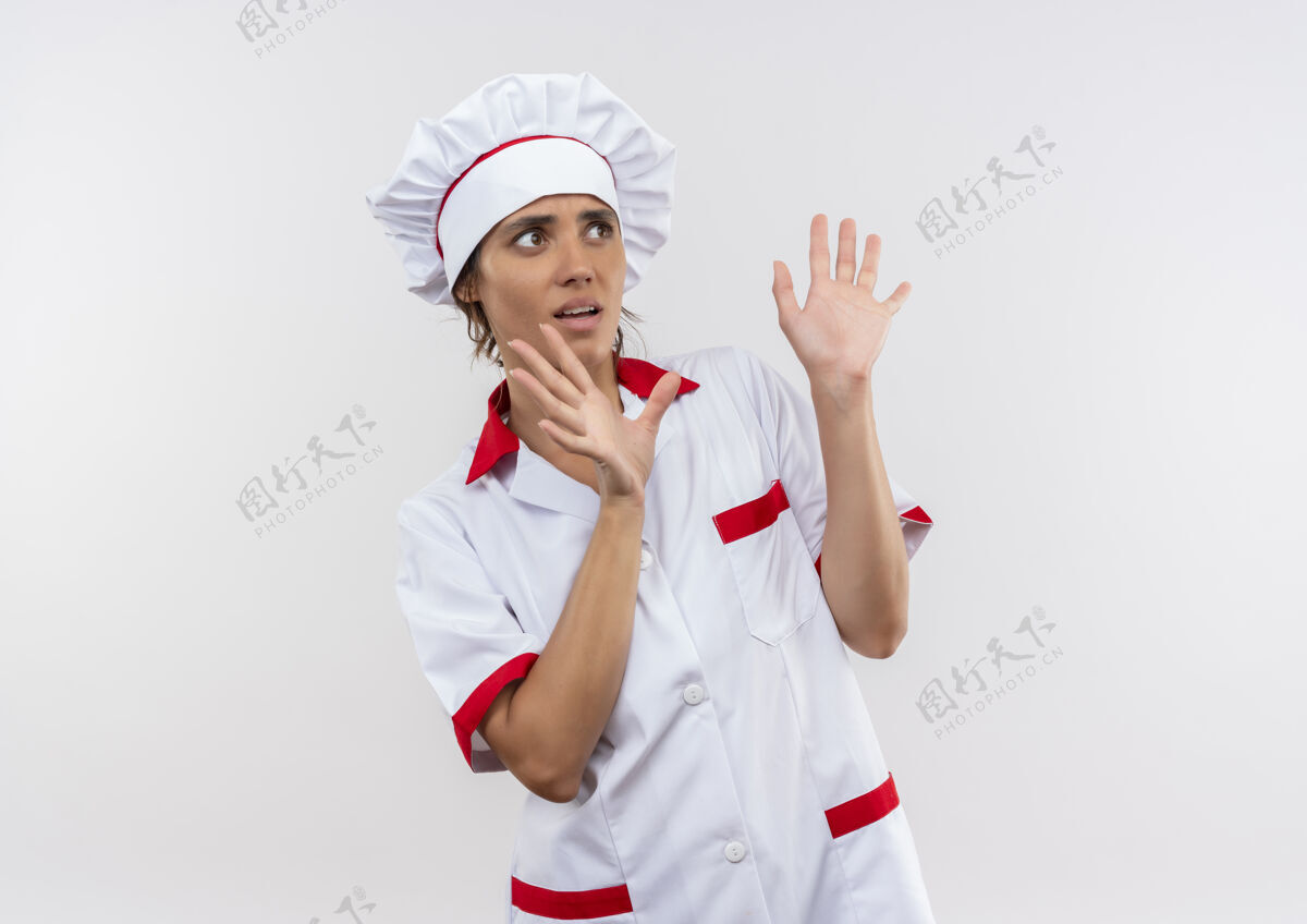 年轻看着旁边吓坏了穿着厨师制服的年轻女厨师举手对着与世隔绝的白墙上留着临摹的空间看穿厨师