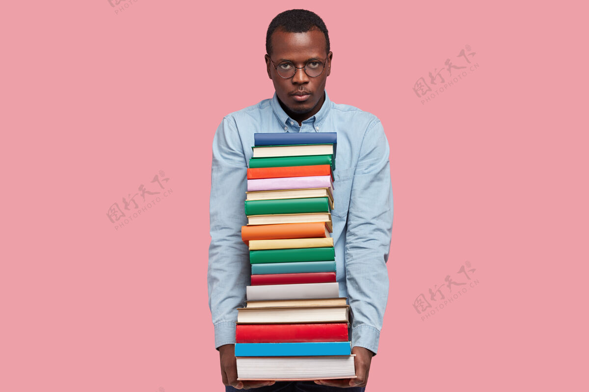 大学严肃的黑皮肤家伙表情不满 有很多书要读 穿着优雅的衣服眼镜大学文学