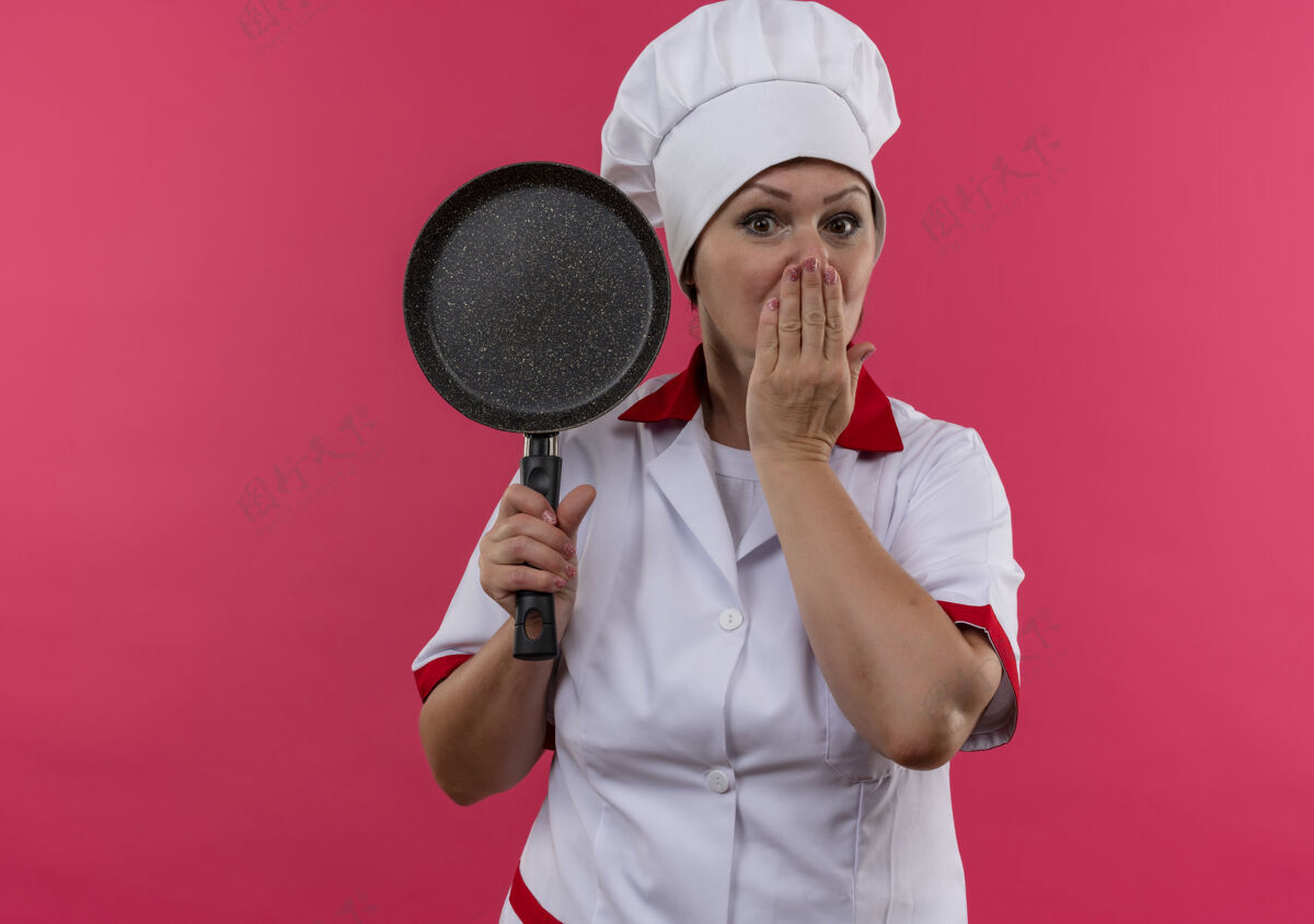 盖吓得中年女厨师穿着厨师制服拿着煎锅捂着嘴用手抄空间厨师嘴害怕